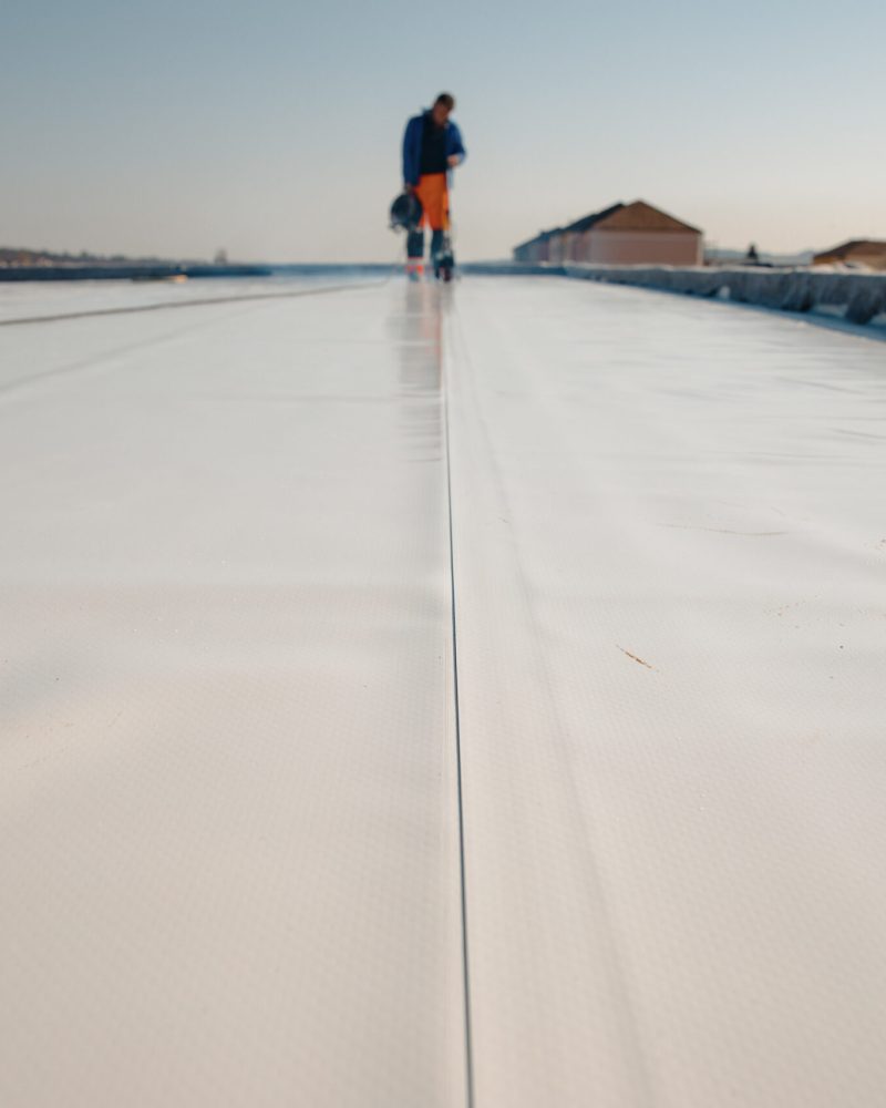 worker-smoothing-seams-on-new-commercial-roofing-p-2026-03-18-14-51-01-utc